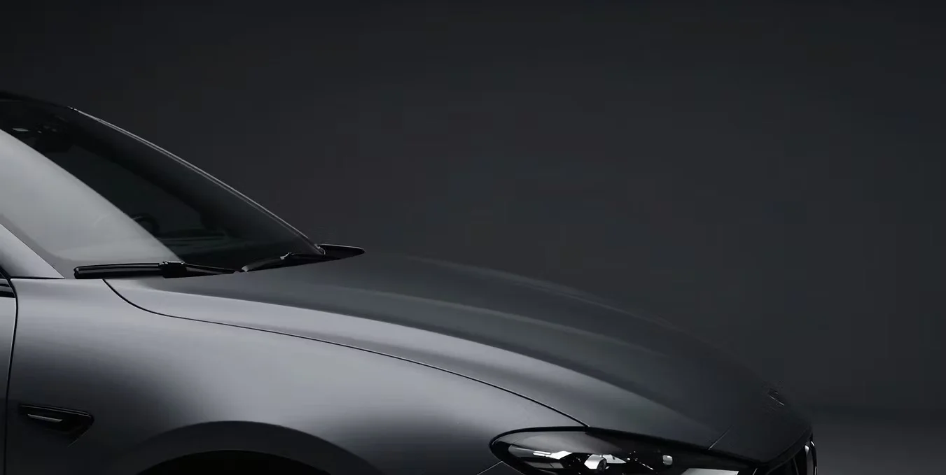 Close view of a dark car’s bonnet and front wheel